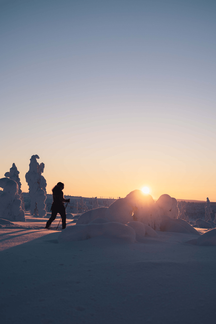 Hiihtäjä auringonlaskussa